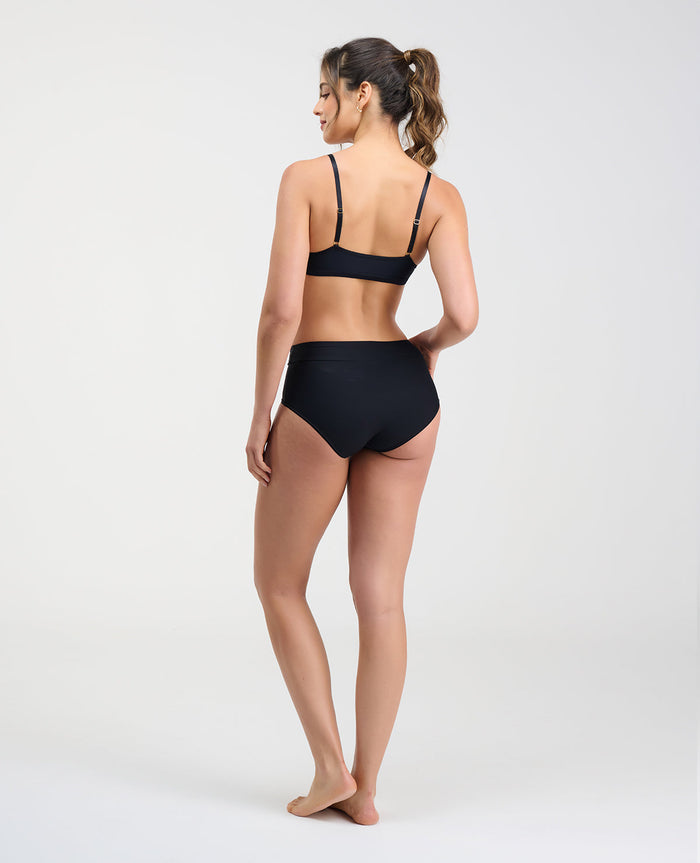 Vista posterior de modelo usando brasier negro con espalda lisa sin broches y cargaderas ajustables.